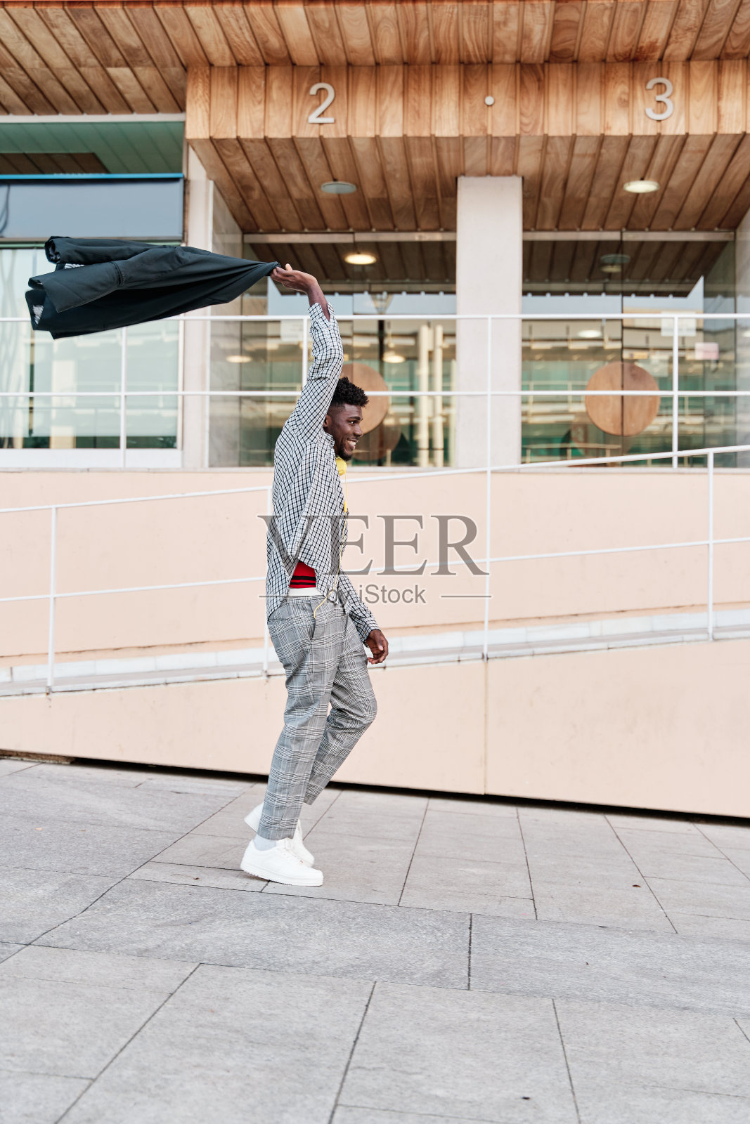 男子在头上挥舞着夹克以示庆祝照片摄影图片