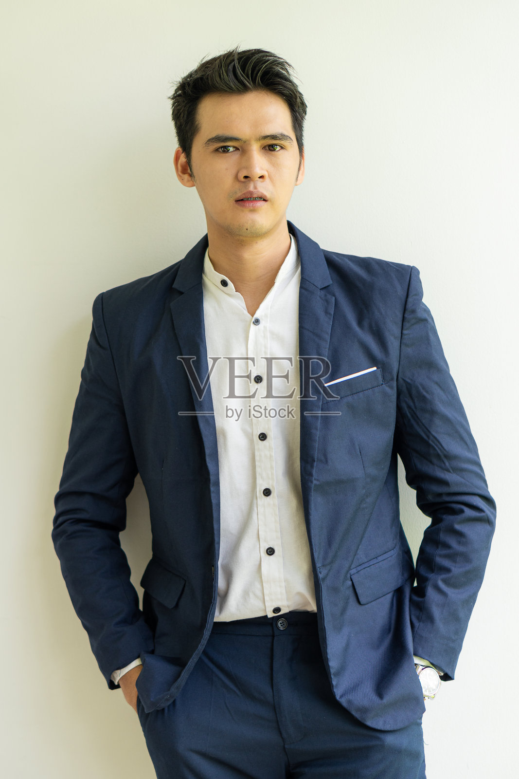 这个英俊友好的年轻人脸上挂着幸福、自信、积极的微笑。有好态度的年轻人的想法，一个白人背景的年轻商人照片摄影图片