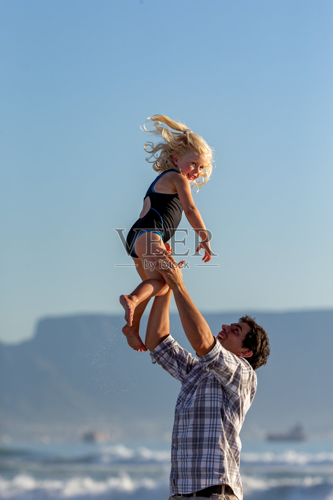 父亲和女儿在海滩上玩耍照片摄影图片