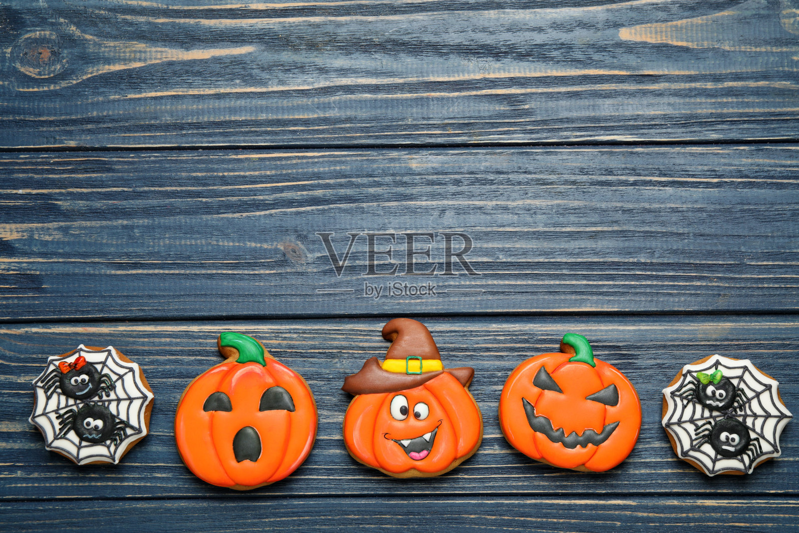 蓝色木桌上平放着美味的万圣节饼干。空间的文本照片摄影图片