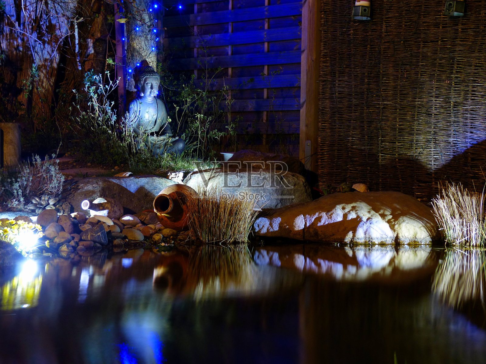 在池塘。晚上禅坐佛。巴伐利亚,德国。照片摄影图片