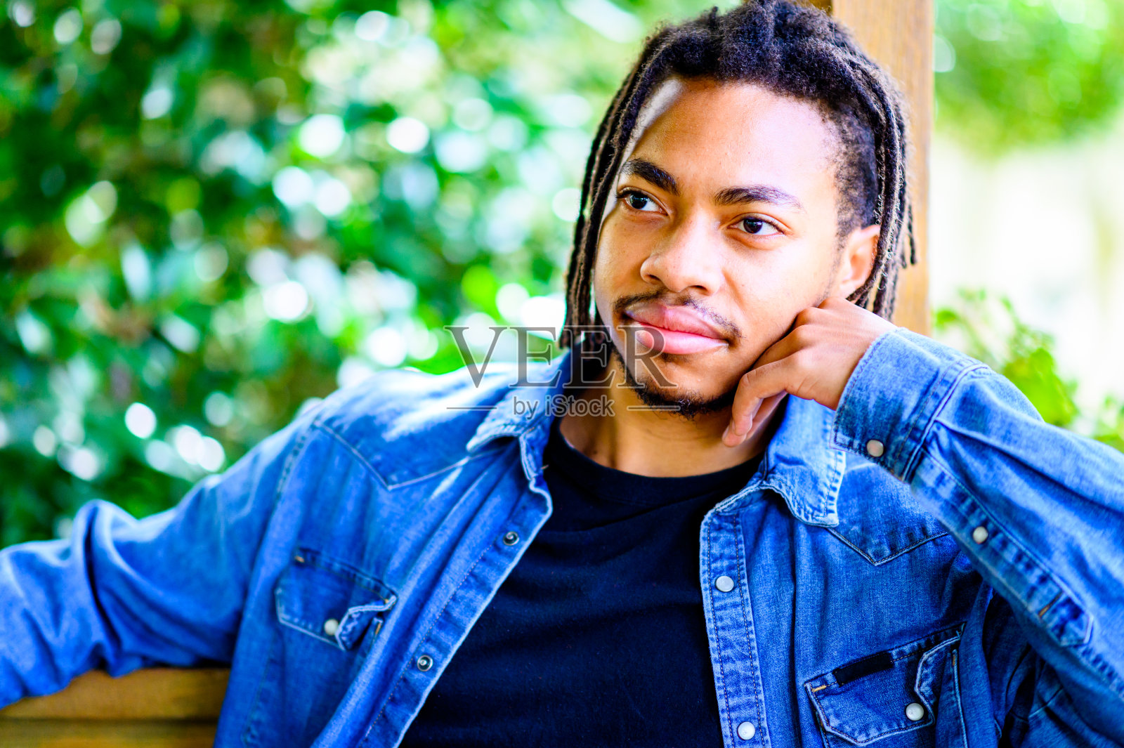 一个英俊的年轻黑人男子在户外拍了一张偷拍的大头照，脸上露出可怕的笑容照片摄影图片