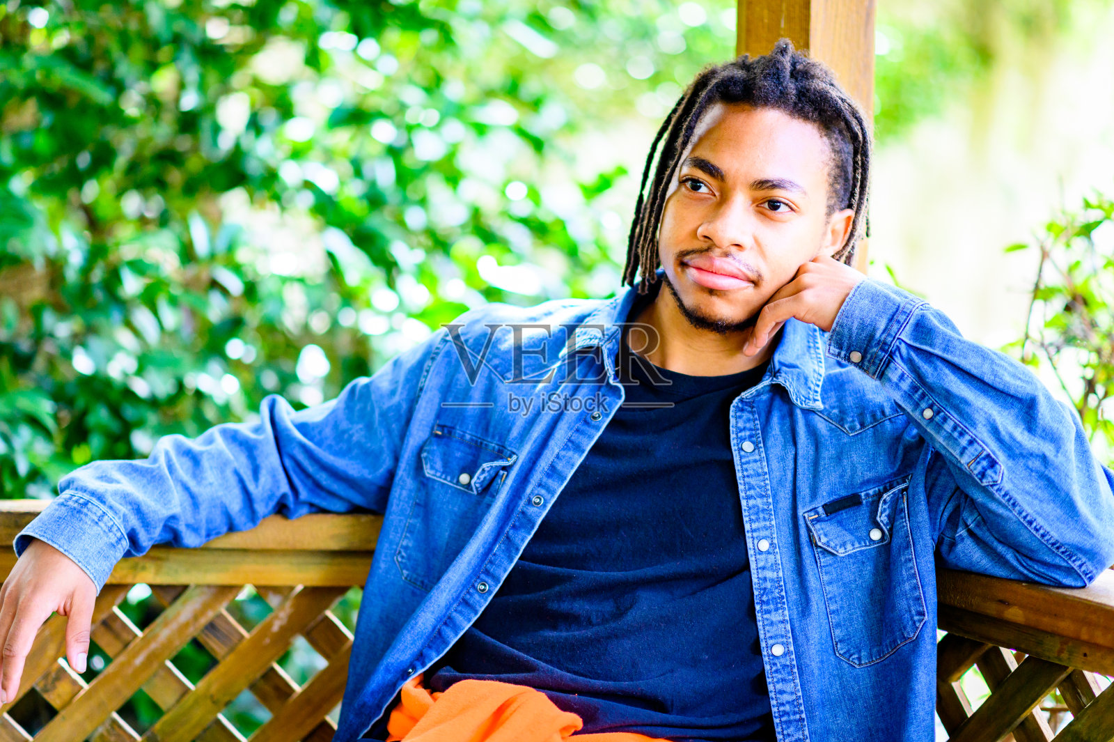 一个英俊的年轻黑人男子在户外拍了一张偷拍的大头照，脸上露出可怕的笑容照片摄影图片