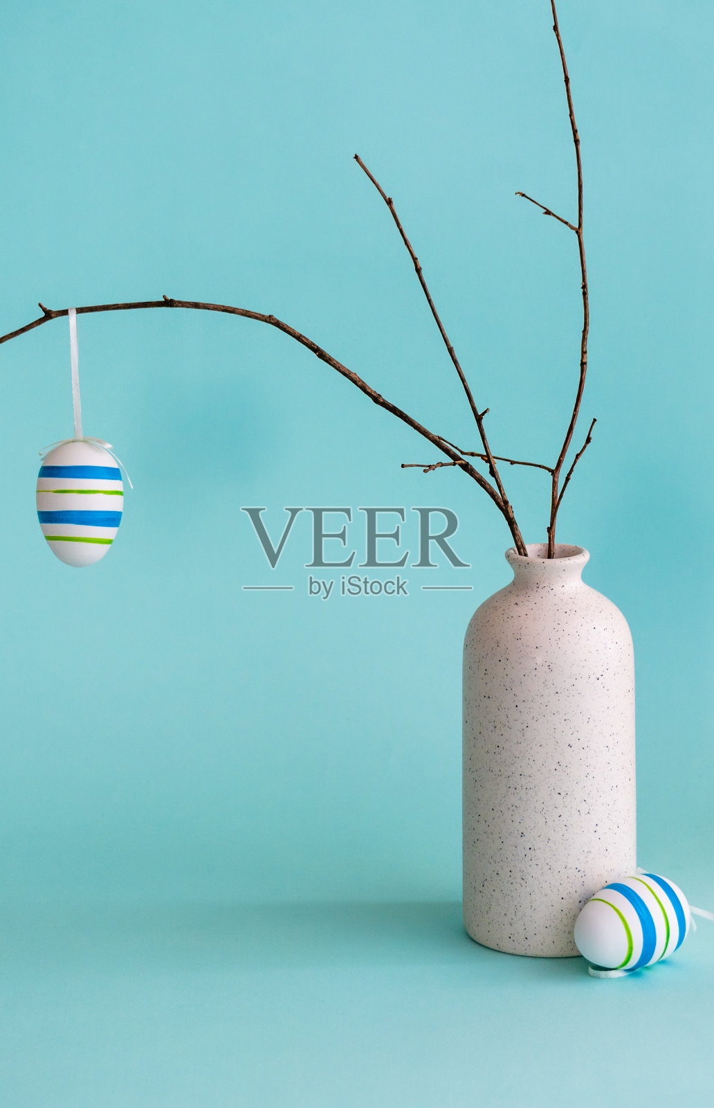 复活节画，鸡蛋挂在干枝上，放置在花瓶里照片摄影图片