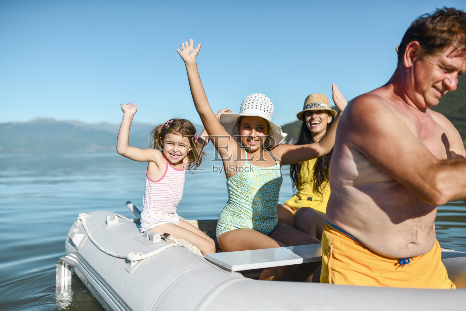 老年男性带着家人在湖上划船照片摄影图片