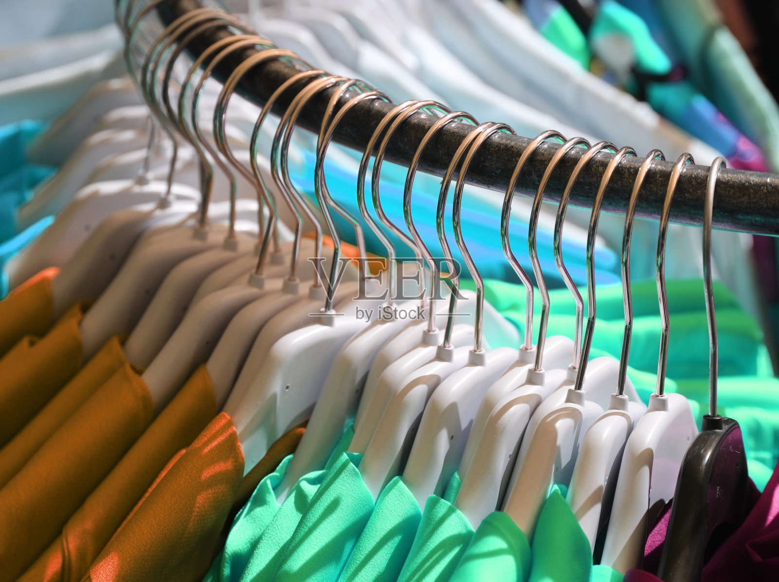 在街市的服装摊位上，挂有晾衣服的衣架照片摄影图片