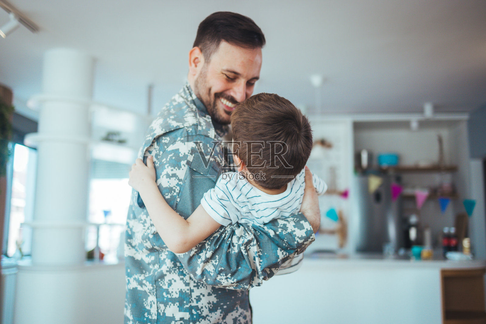 一个小男孩在家见他的军人父亲照片摄影图片