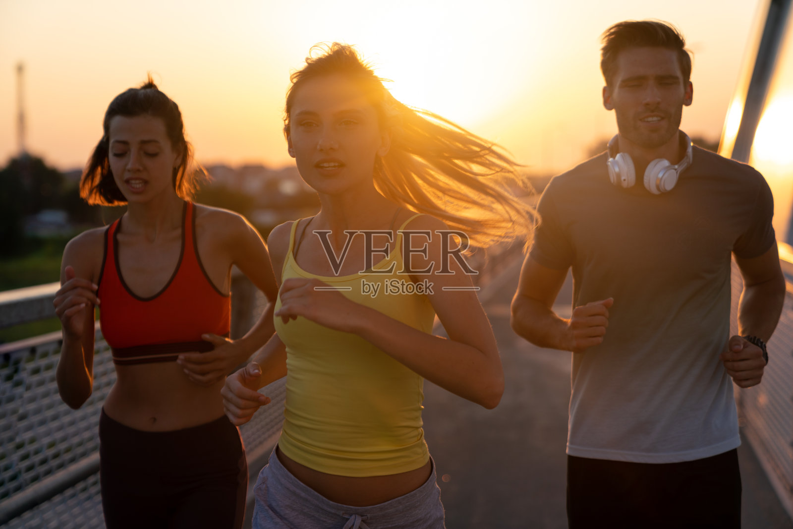 健身运动是人们跑步的生活方式理念。一群在户外慢跑的年轻人。照片摄影图片