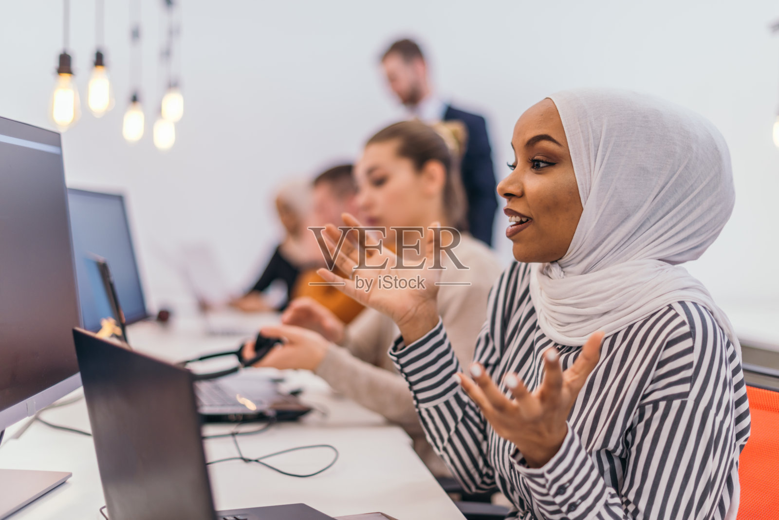 惊讶的女人在明亮的合作工作空间的多台电脑照片摄影图片