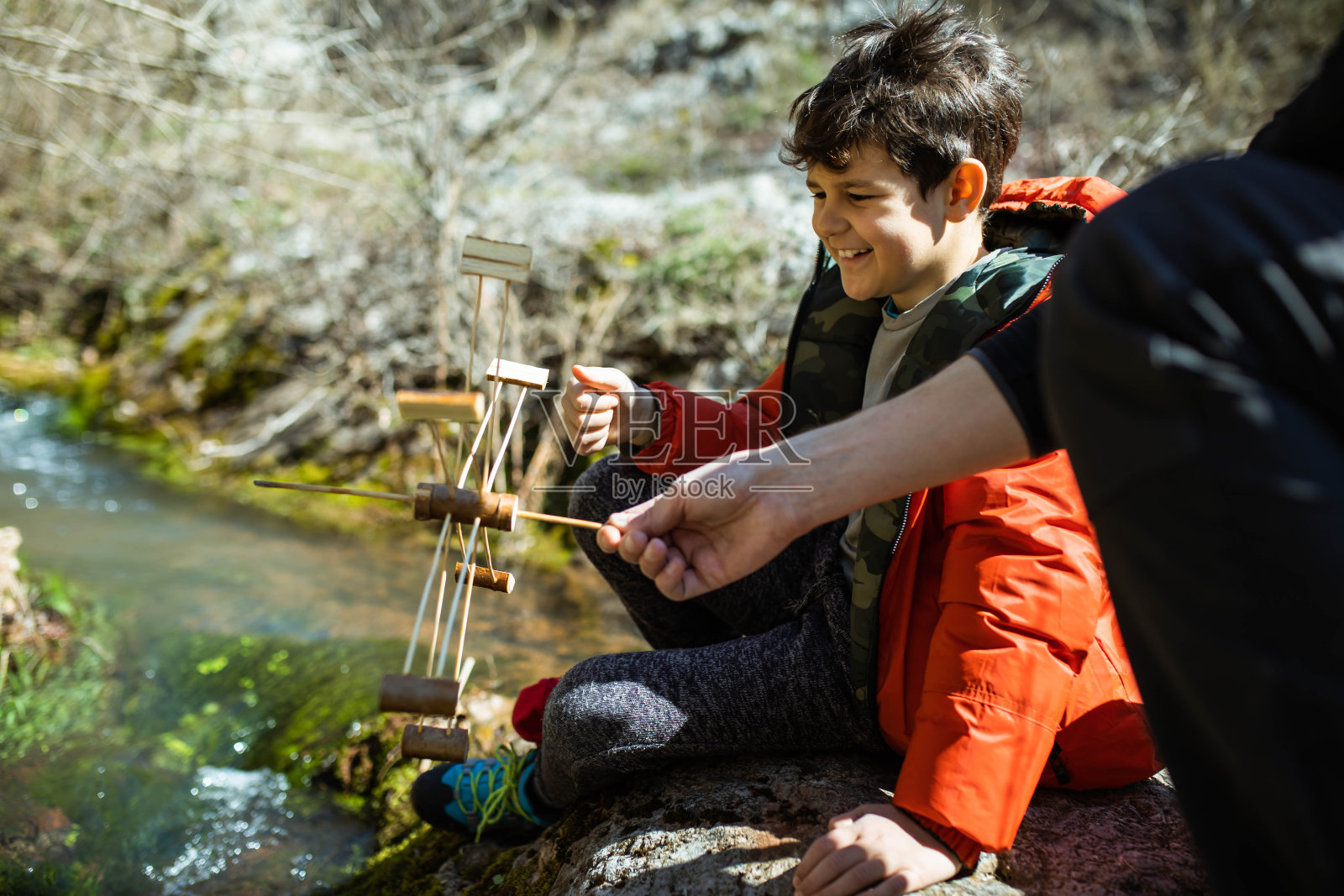 一个快乐的男孩在山涧旁推着水车照片摄影图片