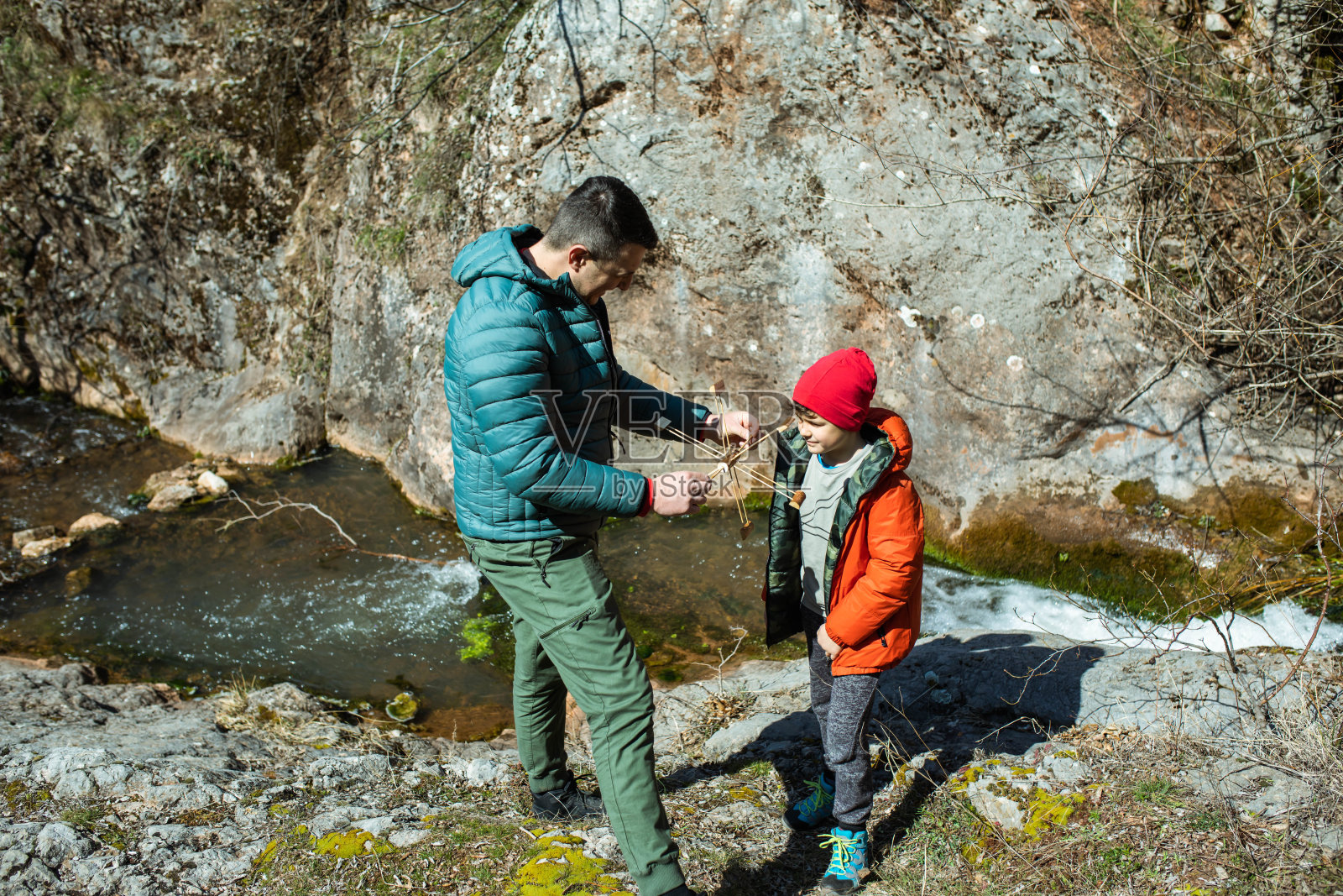 父子俩驾着小水车在山间小溪旁照片摄影图片