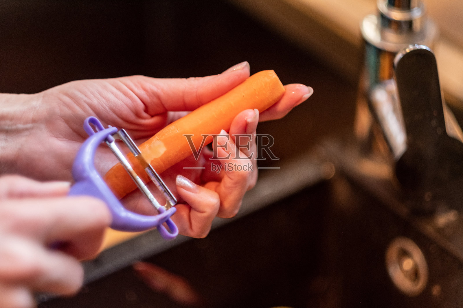 一个女人在削胡萝卜照片摄影图片