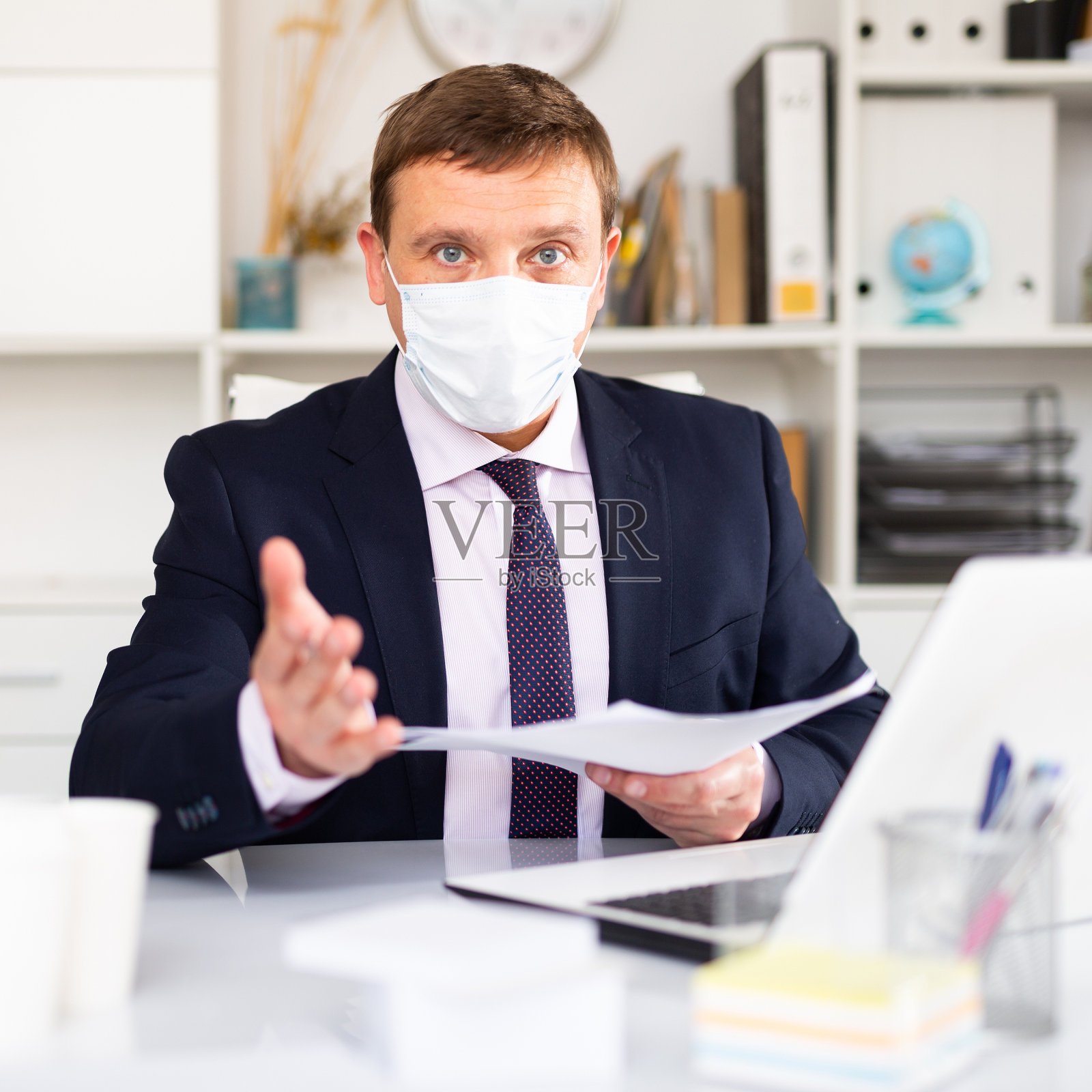 戴着防护口罩的人在办公室工作照片摄影图片