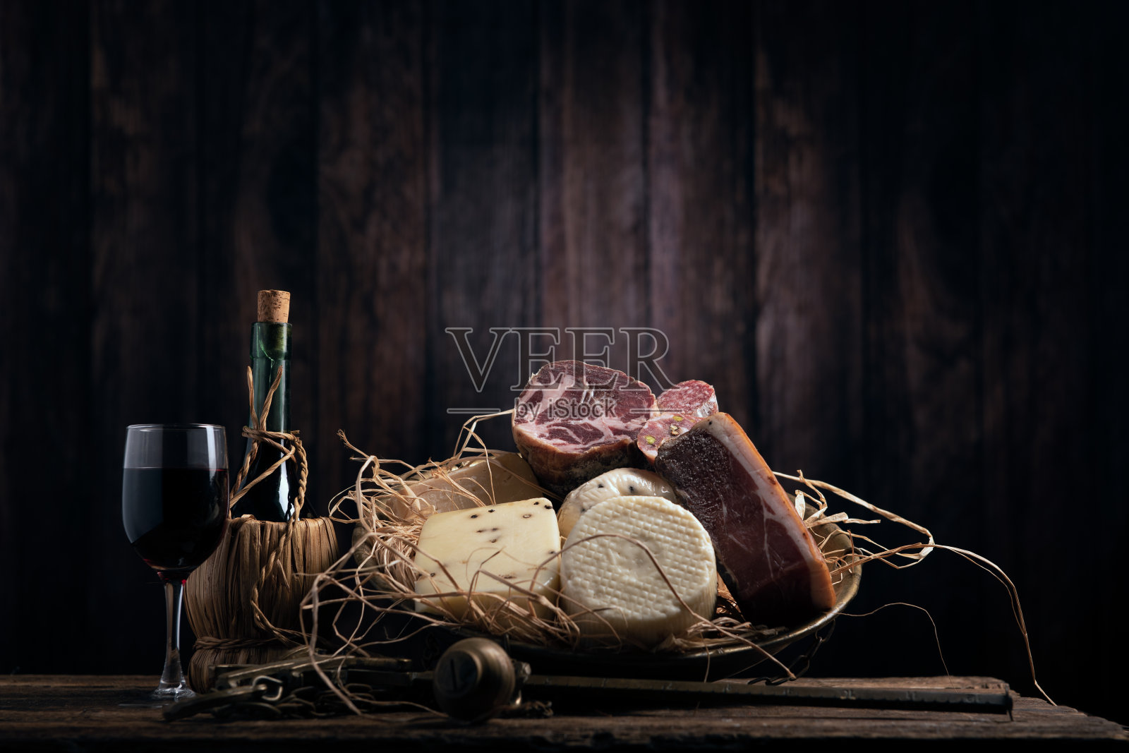 在木制背景的木桌上摆放着各式各样的自制奶酪和意大利腊肠照片摄影图片