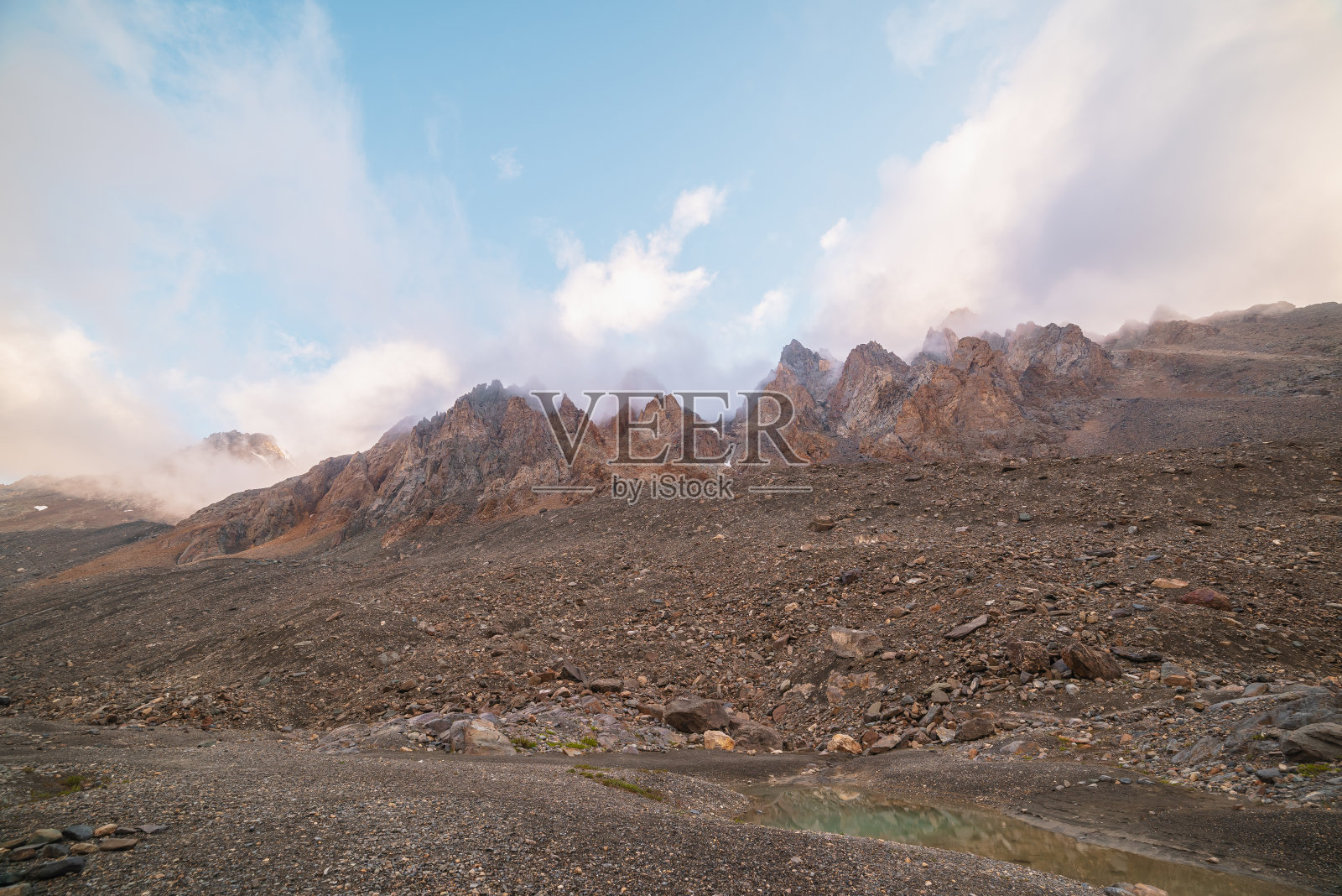 风景优美的高山景观，岩石山脉在早晨的阳光下稠密的低云。色彩缤纷的山景，在厚厚的低云中点缀着尖锐的岩石。俯瞰低云下的落基山脉，真是太棒了。照片摄影图片