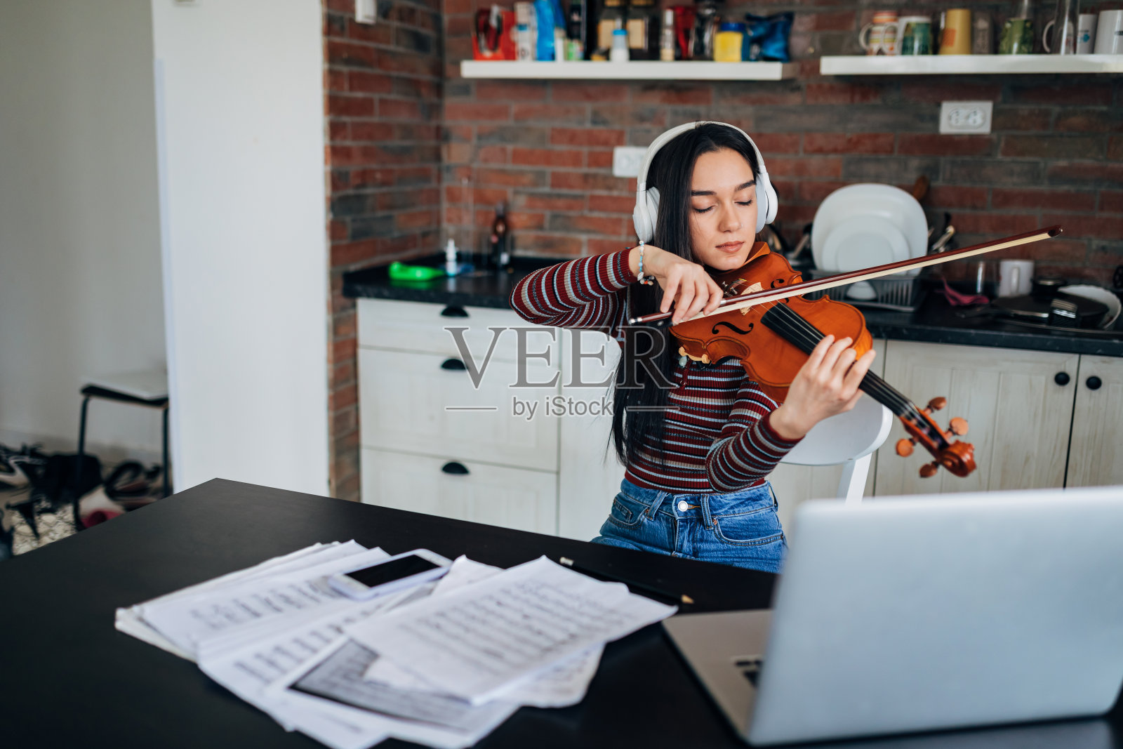 这位女小提琴手通过在线教学应用程序参加在线小提琴课程。照片摄影图片