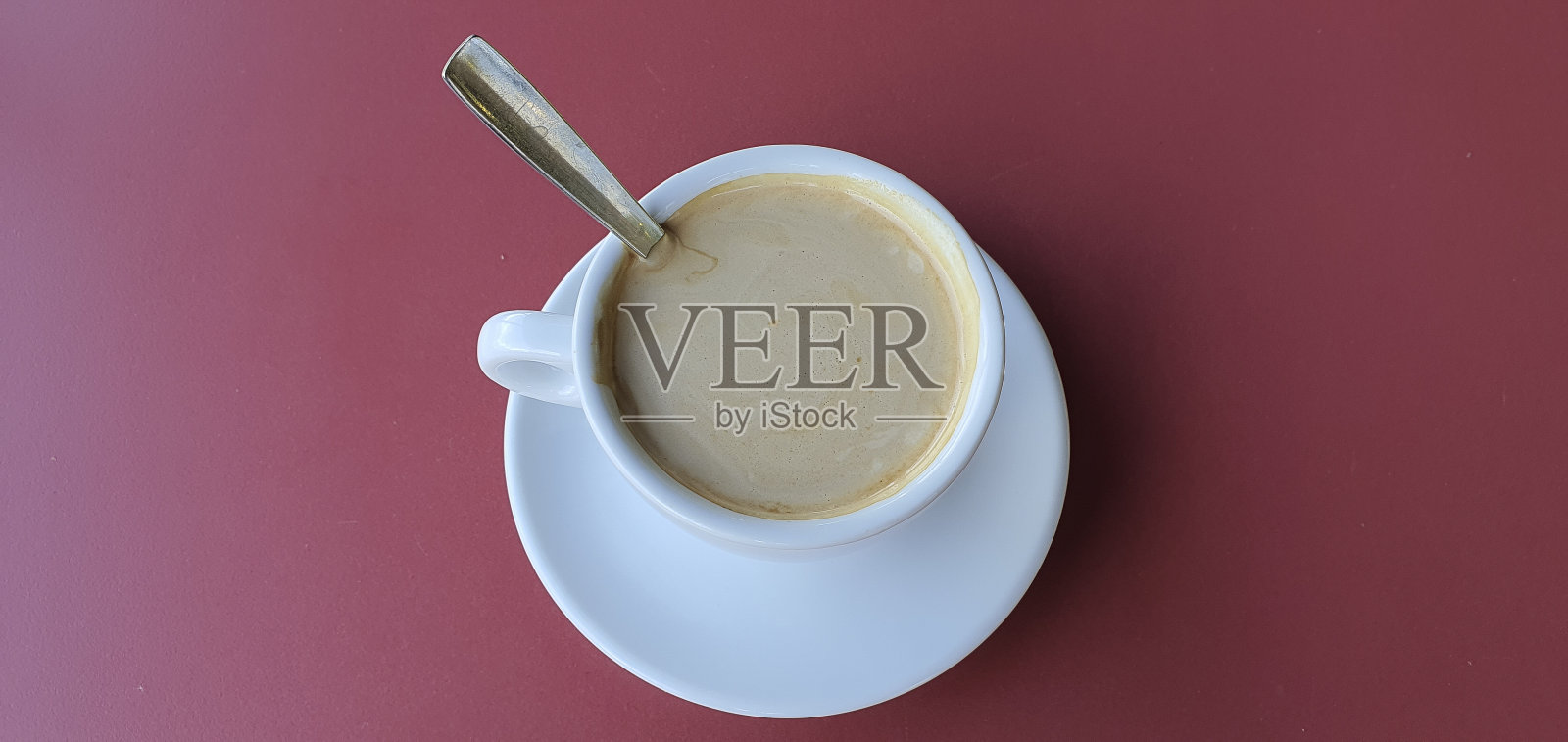 一杯牛奶咖啡在红色的背景上。照片摄影图片