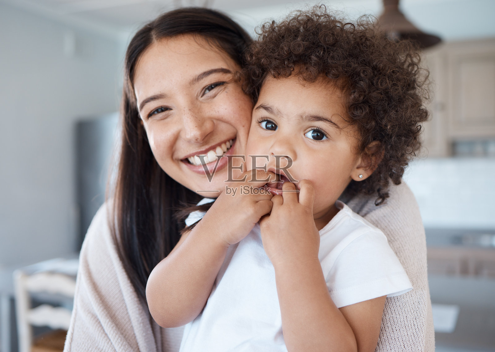 一个年轻的母亲抱着她的女儿在家里照片摄影图片