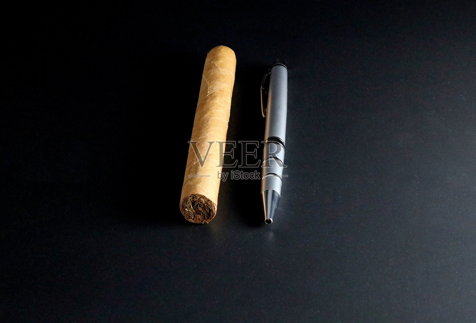一支古巴雪茄旁边的豪华钢笔照片摄影图片
