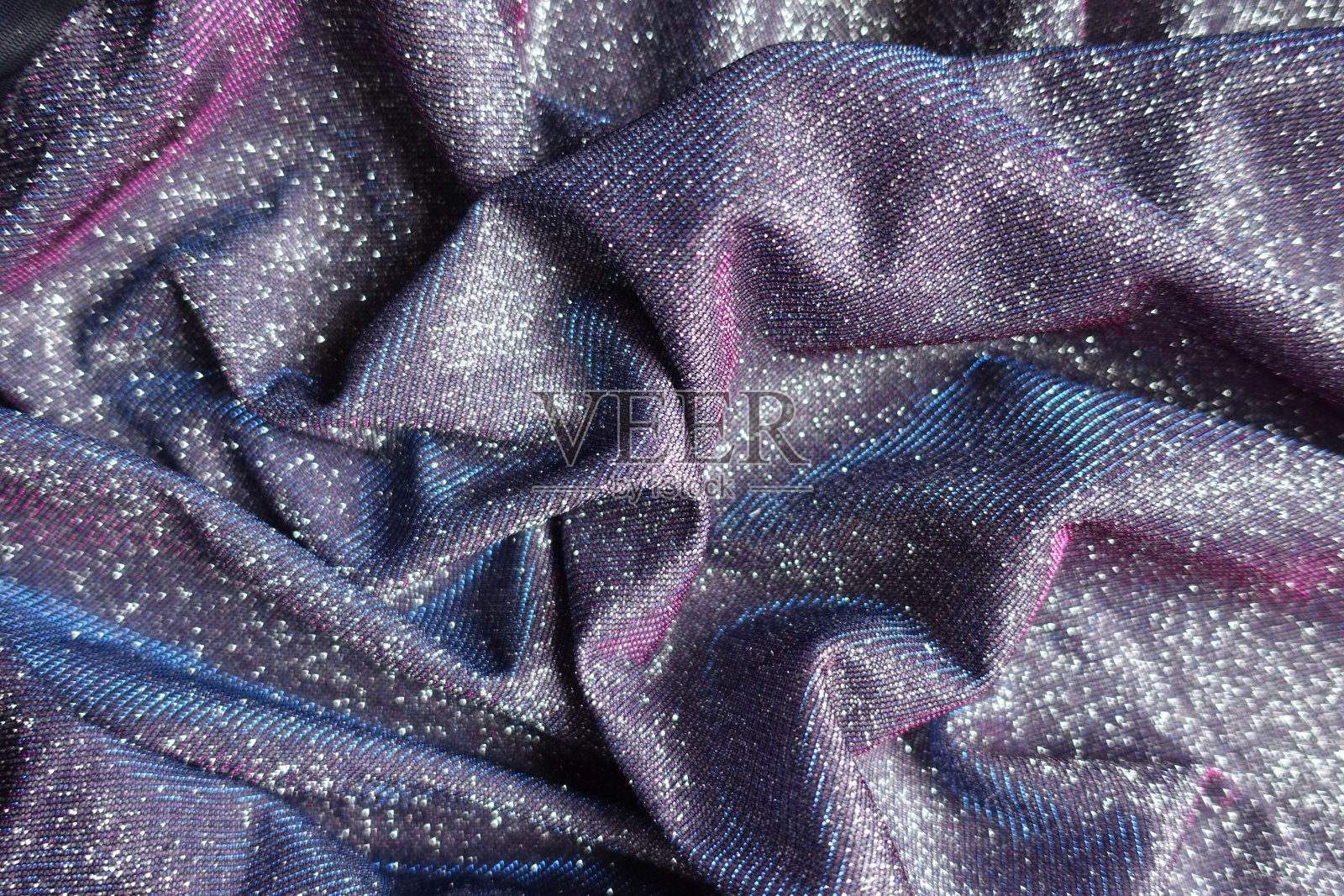 皱褶闪亮的紫色lurex织物，带有粉色和蓝色的色调照片摄影图片