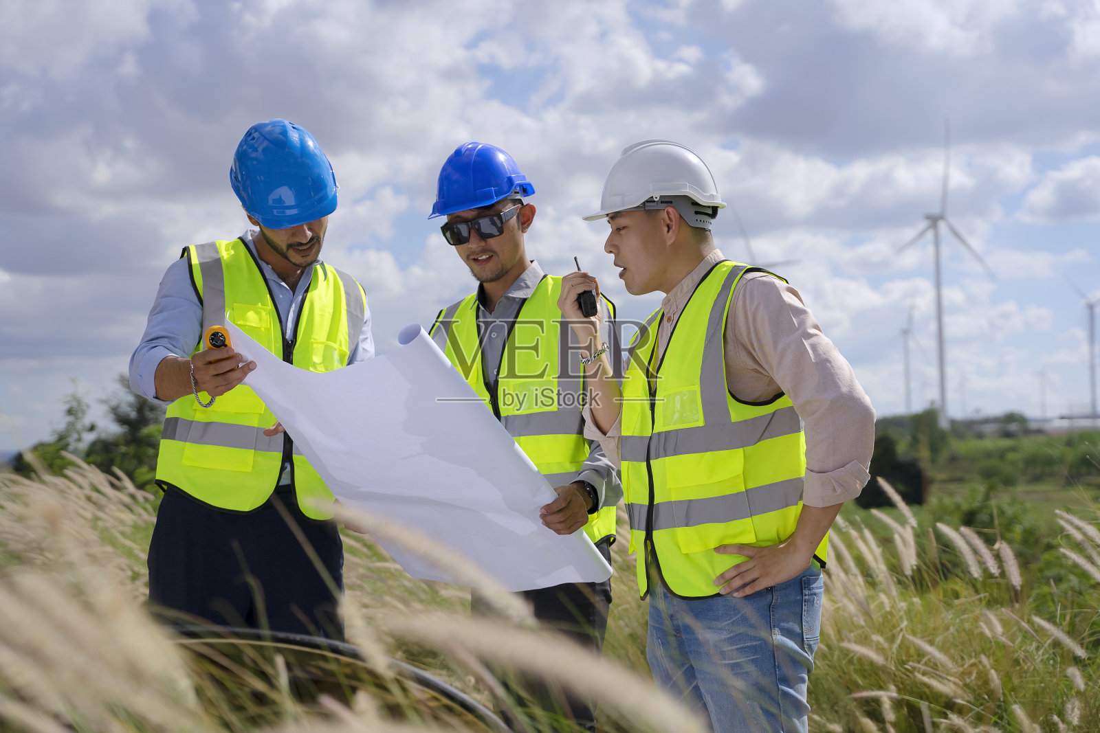 在电力工地的蓝领工人与风车照片摄影图片