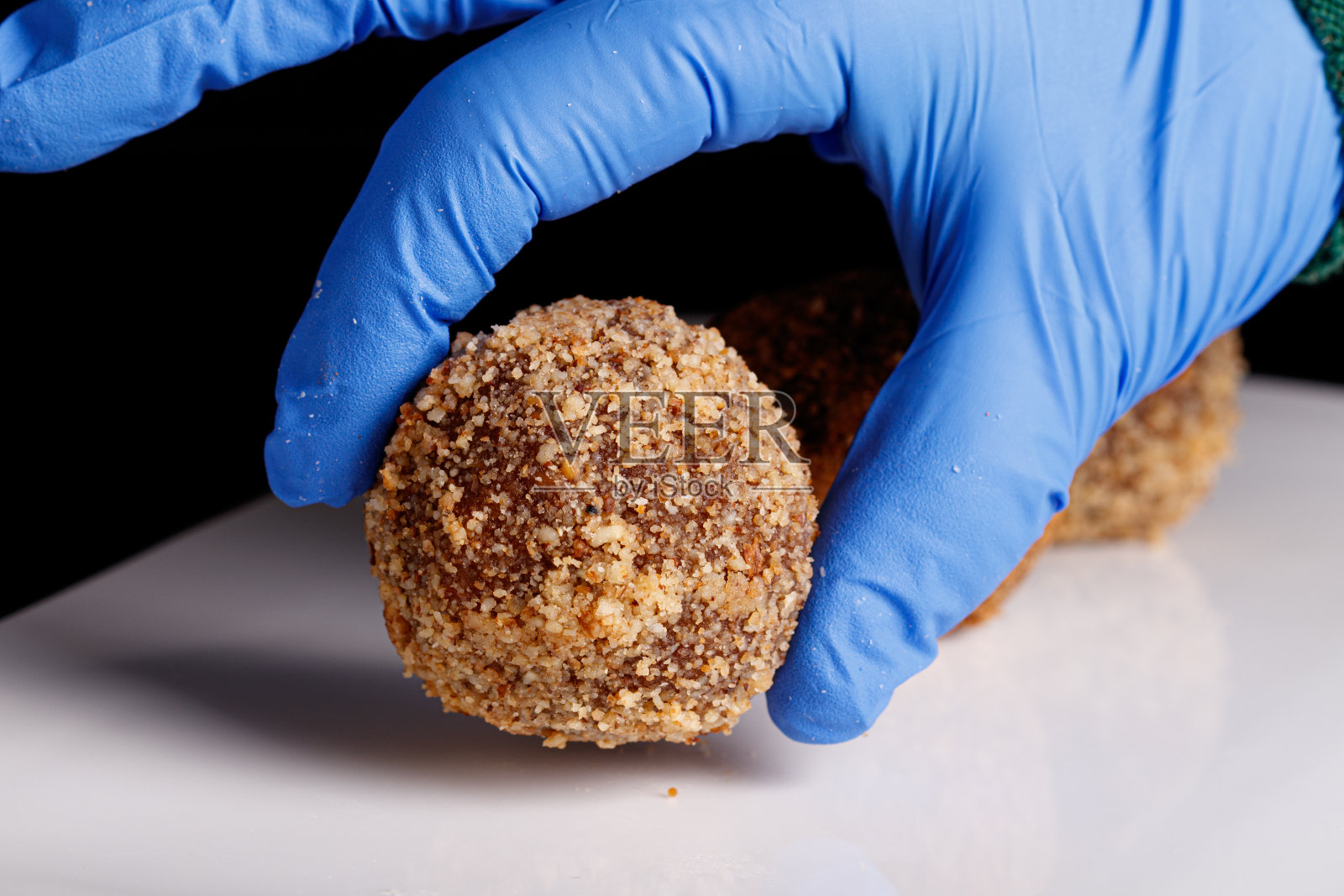 美丽的松露糖在黑色背景的白色盘子上照片摄影图片