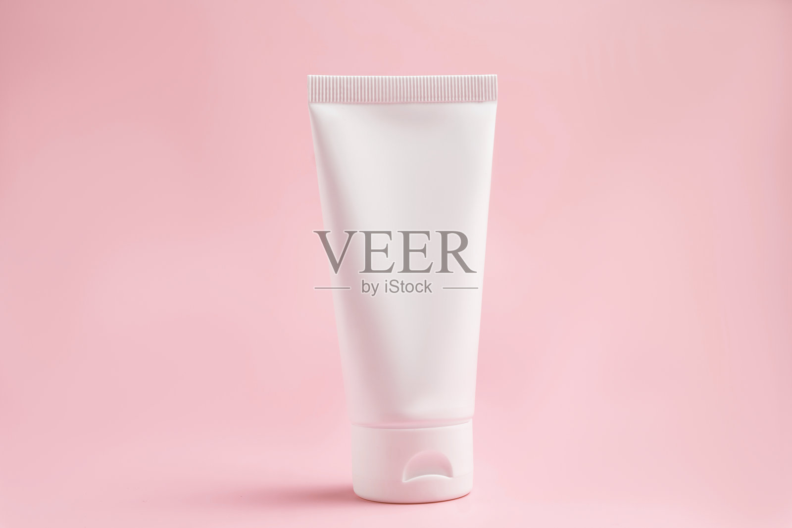 白色挤压瓶塑料管的模型，用于医药或化妆品品牌-奶油，凝胶，皮肤护理，牙膏。化妆品瓶容器在粉红色的背景。极简主义照片摄影图片