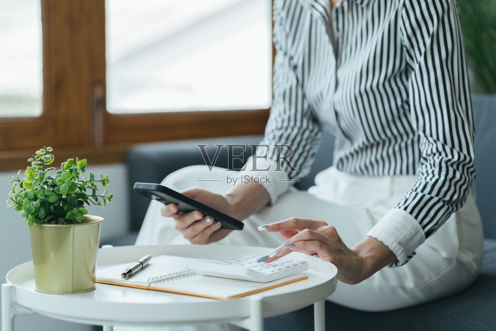 商务人员在办公桌边用计算器计算数字，财务会计概念照片摄影图片