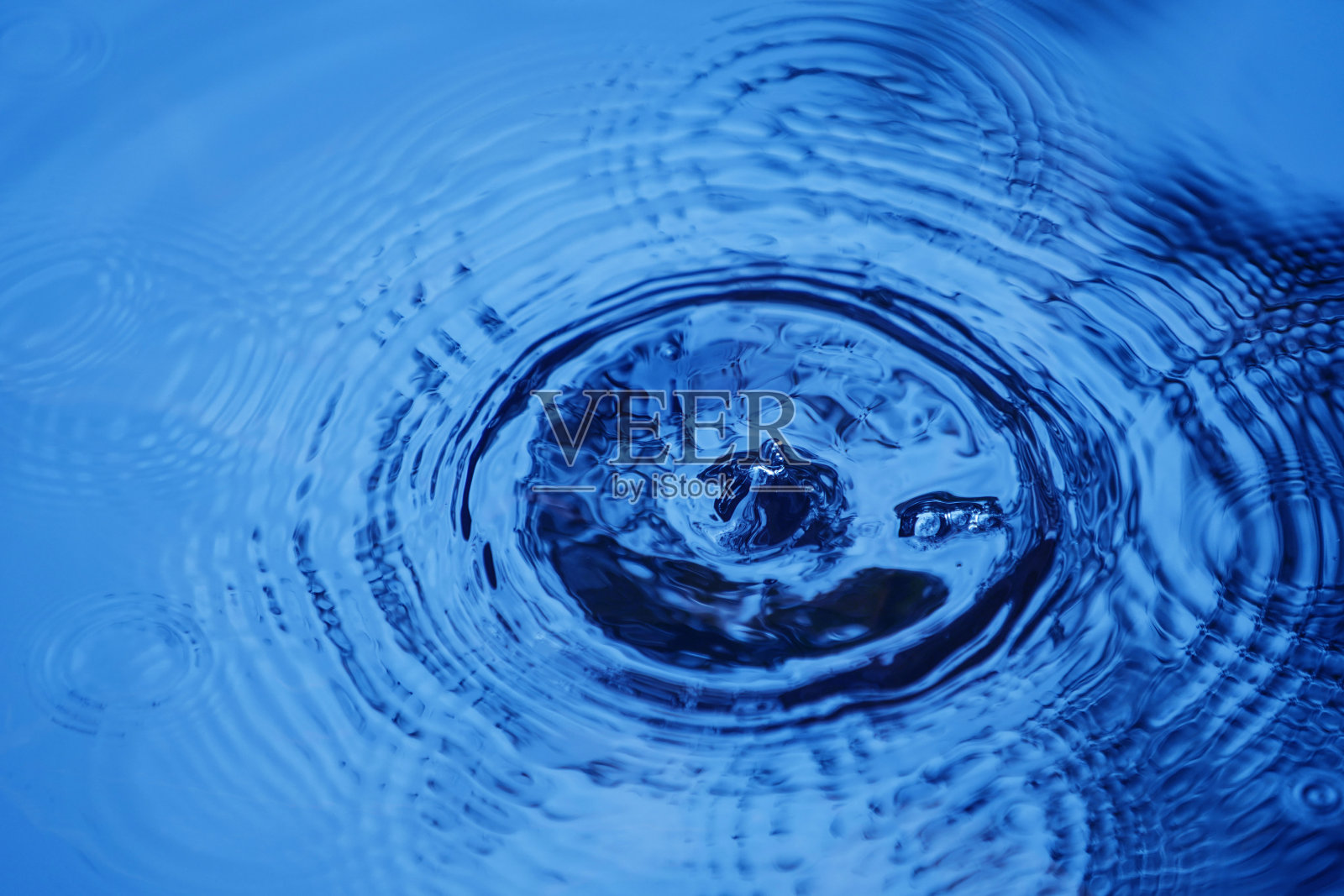 水滴影响表面，在表面形成环。照片摄影图片