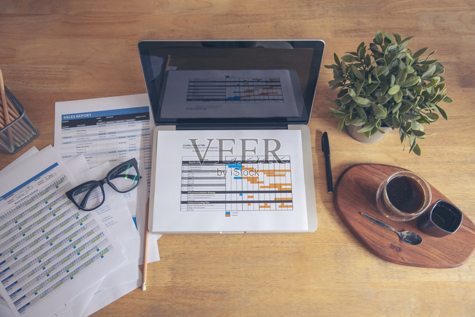 办公室笔记本电脑业务财务文件图表和图表在木桌上与咖啡杯。将笔记本电脑平放在办公桌上。没有人在业务工作空间的业务图表模型照片摄影图片