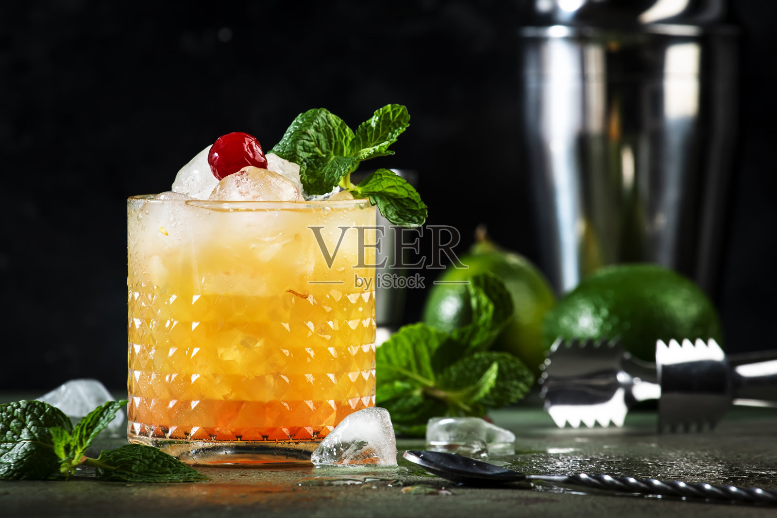 迈泰是一款新潮的酒精鸡尾酒，内含朗姆酒、利口酒、糖浆、酸橙汁、薄荷和碎冰。黑色背景，工具条，复制空间照片摄影图片