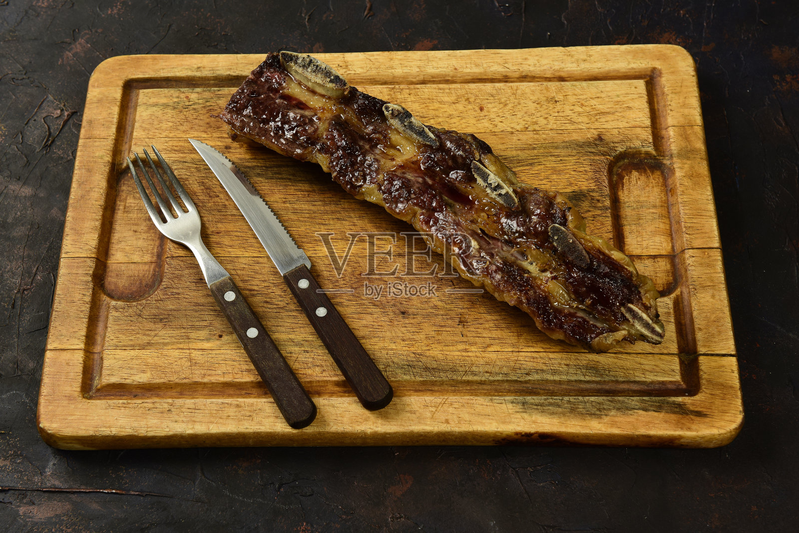 烤牛排骨上桌，阿根廷传统美食，Asado烧烤，巴塔哥尼亚，阿根廷。照片摄影图片