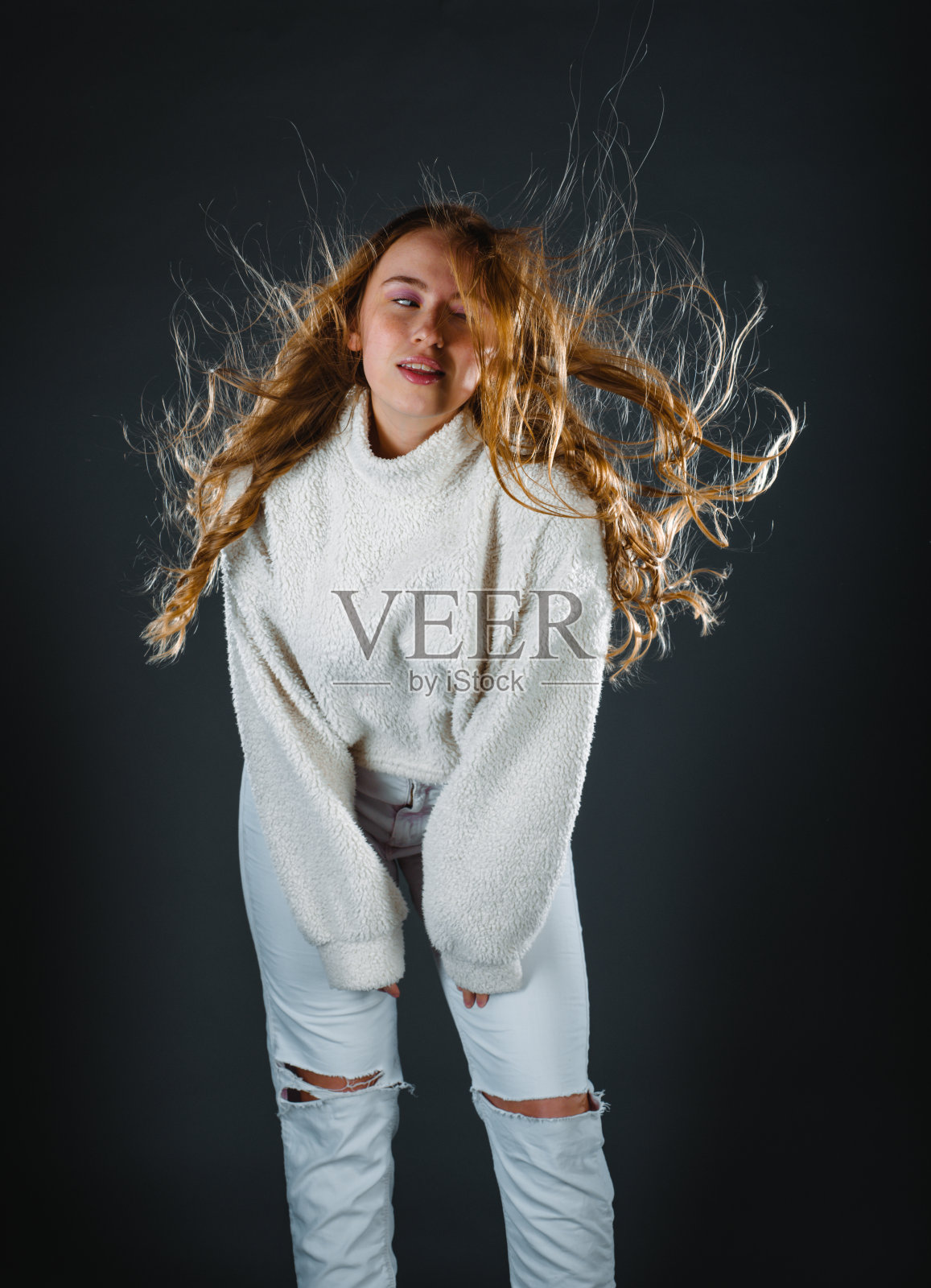 年轻美丽的女人在新的休闲布摆姿势孤立在黑暗的背景照片摄影图片