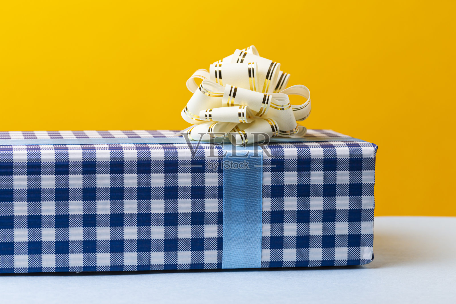 包装复选框与蝴蝶结圣诞节和新年礼物的蓝色和白色放在黄色照片摄影图片