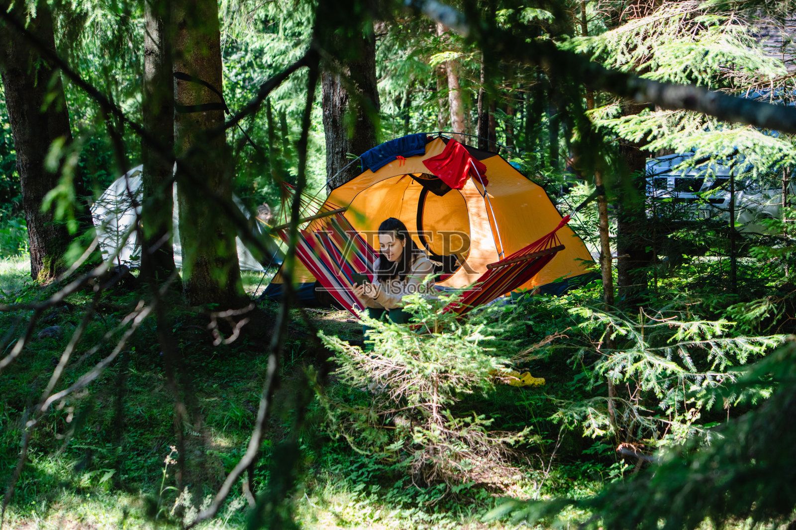 一个女人躺在吊床帐篷和背景车里照片摄影图片