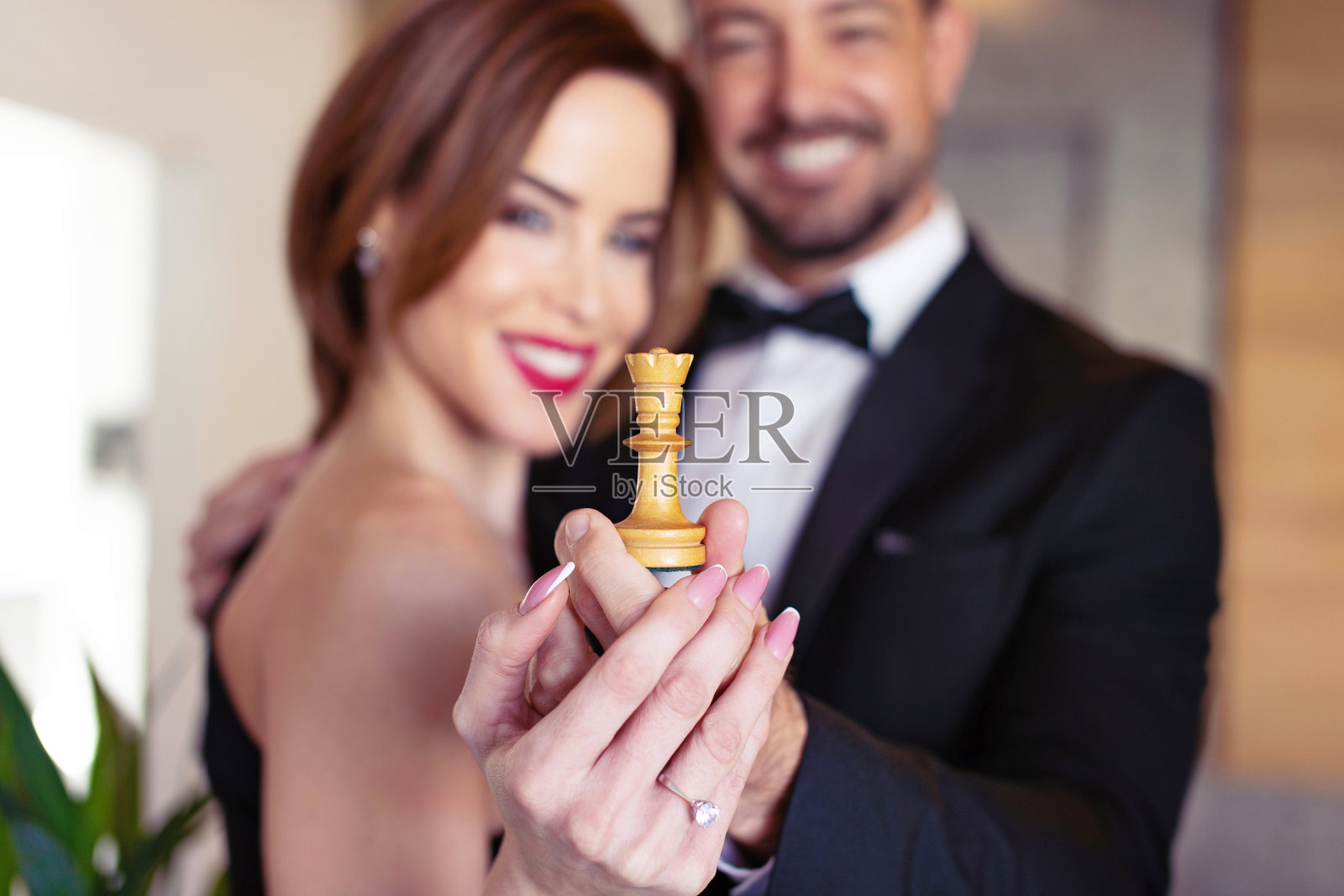 幸福的年轻夫妇捧着白棋皇后照片摄影图片