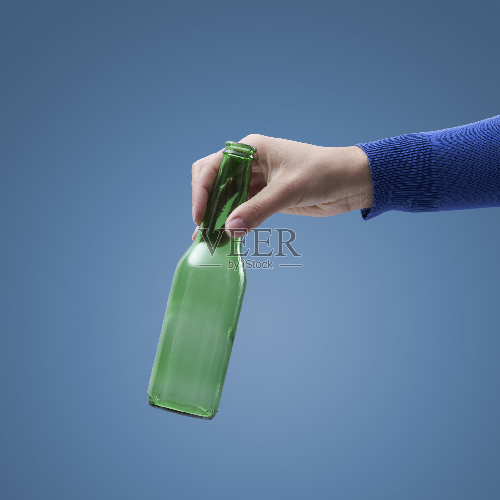 手里拿着一个空玻璃瓶照片摄影图片