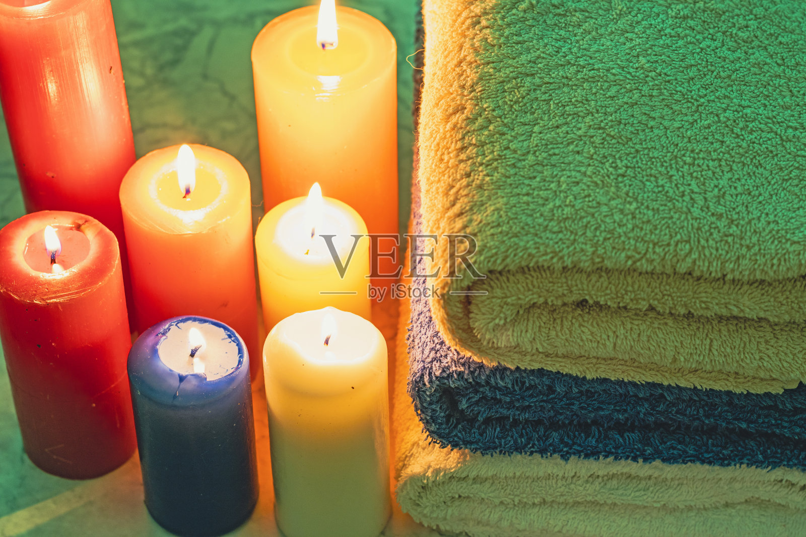 毛巾叠在一起，周围放着蜡烛照片摄影图片