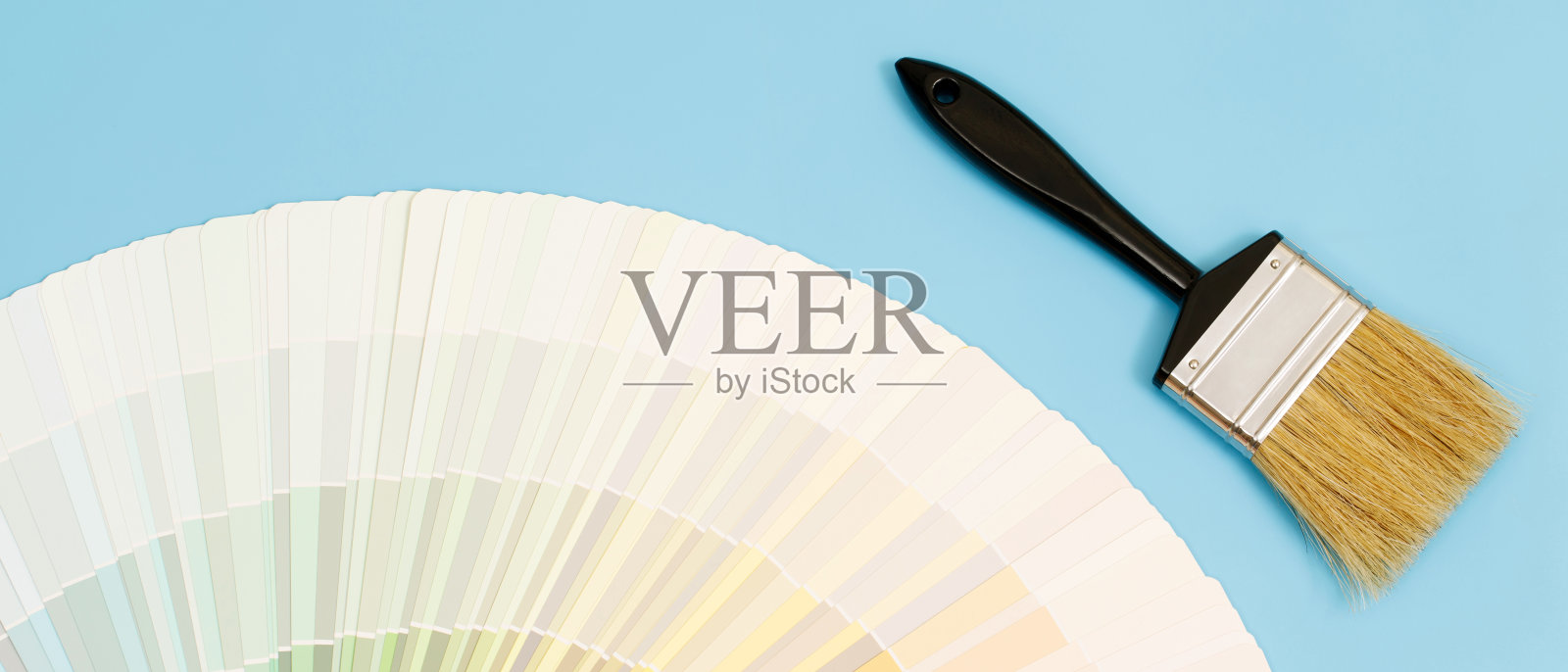 一位油漆工正在为房子内部的墙壁选择一种颜色。与内部照片摄影图片