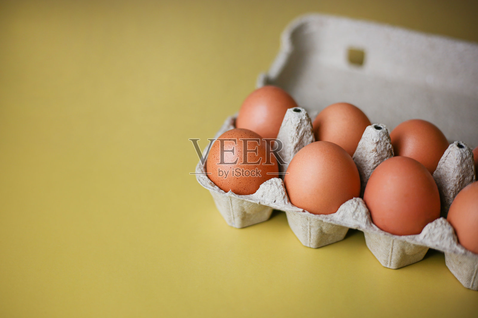 棕色鸡蛋在生态包装由回收材料在一个孤立的浅黄色背景照片摄影图片