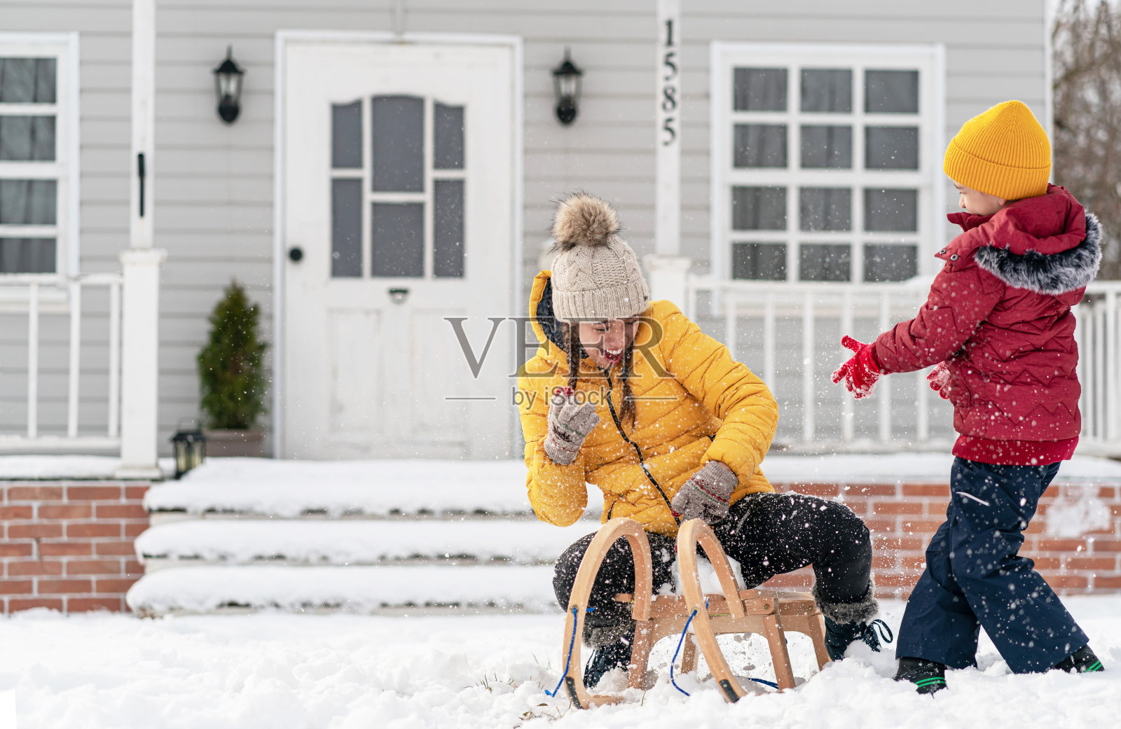 快乐的孩子们，兄弟姐妹们在冬天的户外玩雪橇。兄弟姐妹的家庭时光照片摄影图片