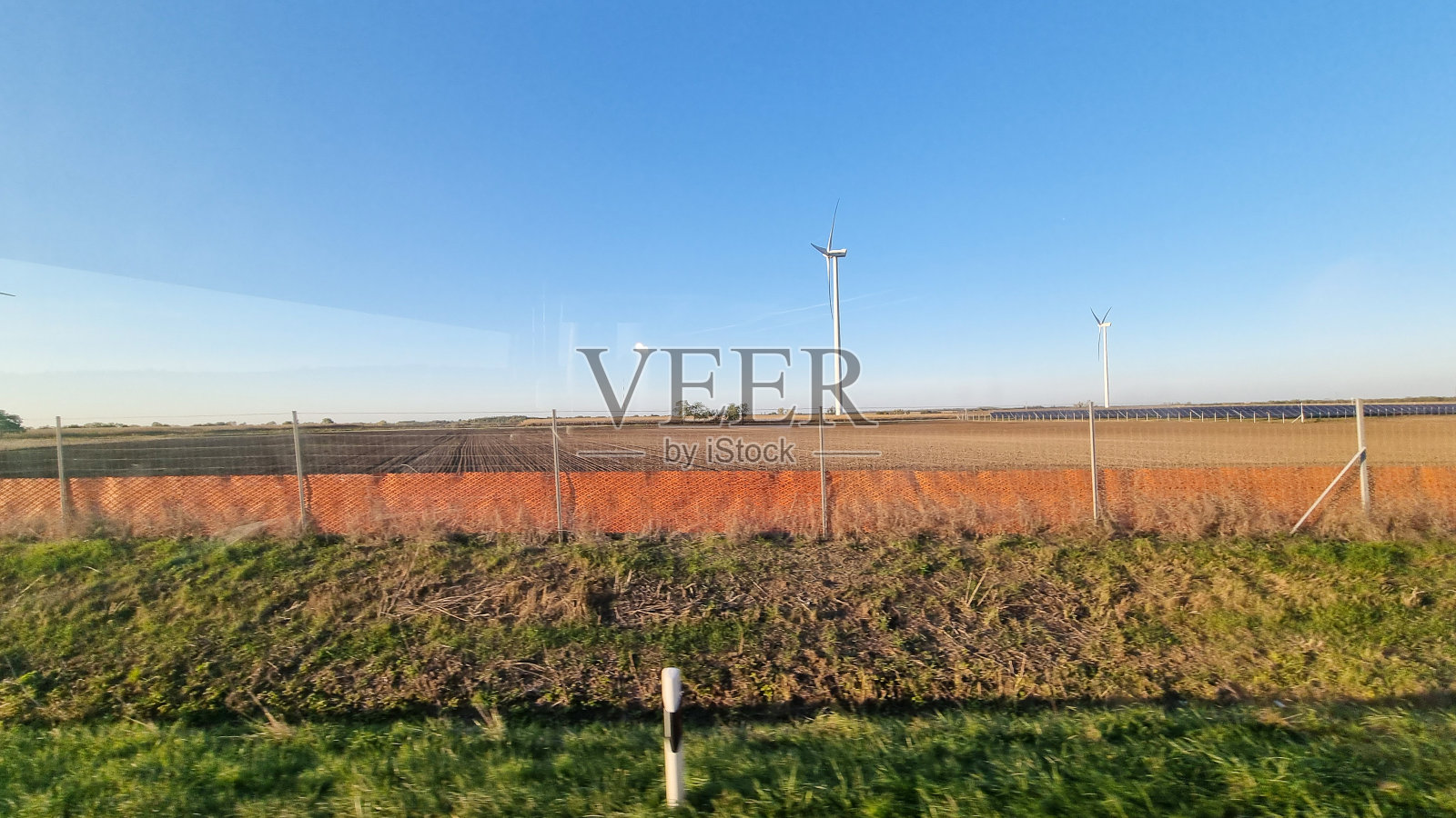 阳光明媚的天空下，风力涡轮机和麦田。照片摄影图片