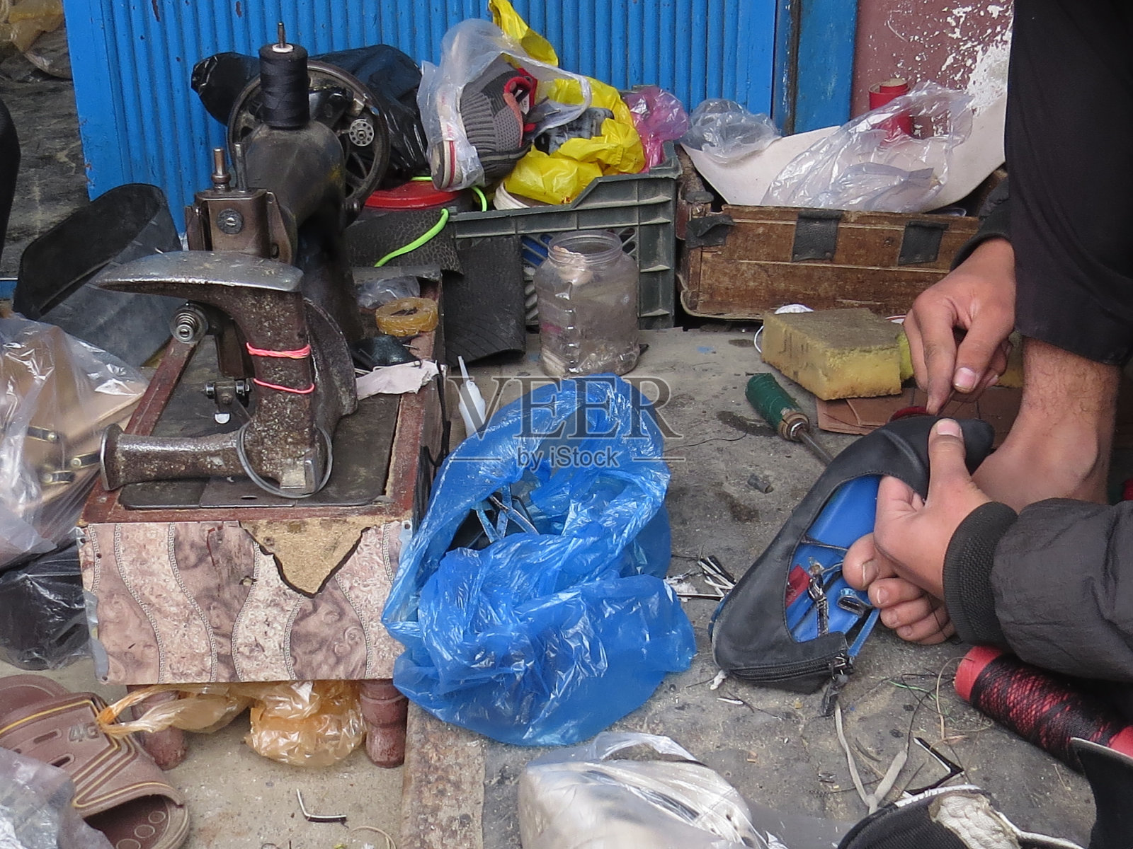 补鞋匠商店。鞋匠在缝靴子。小生意。照片摄影图片