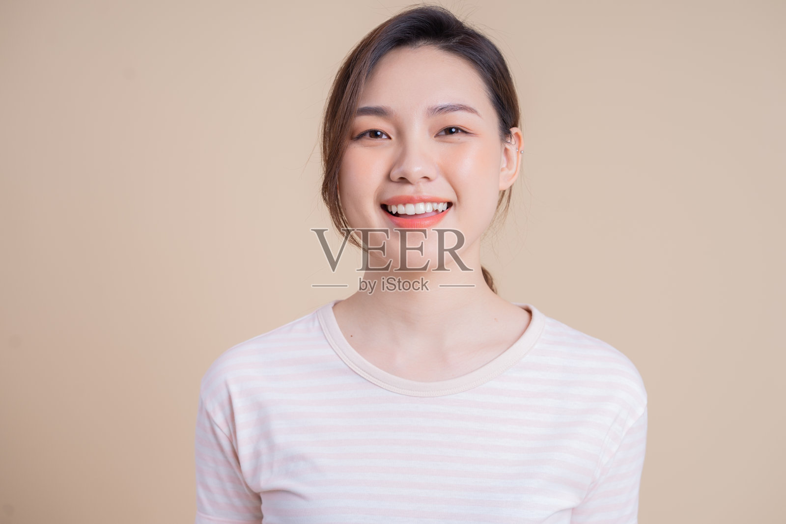 在背景上摆姿势的年轻亚洲女孩的肖像照片摄影图片