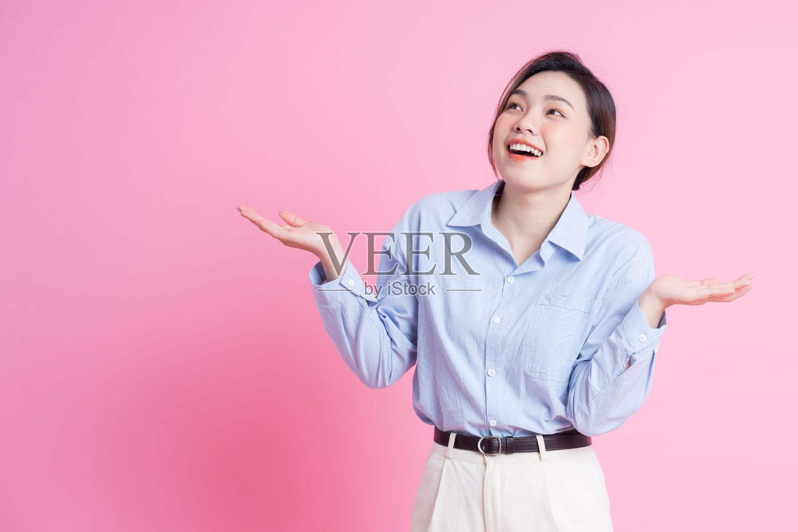 年轻美丽的亚洲女孩在粉红色背景摆姿势的图像照片摄影图片