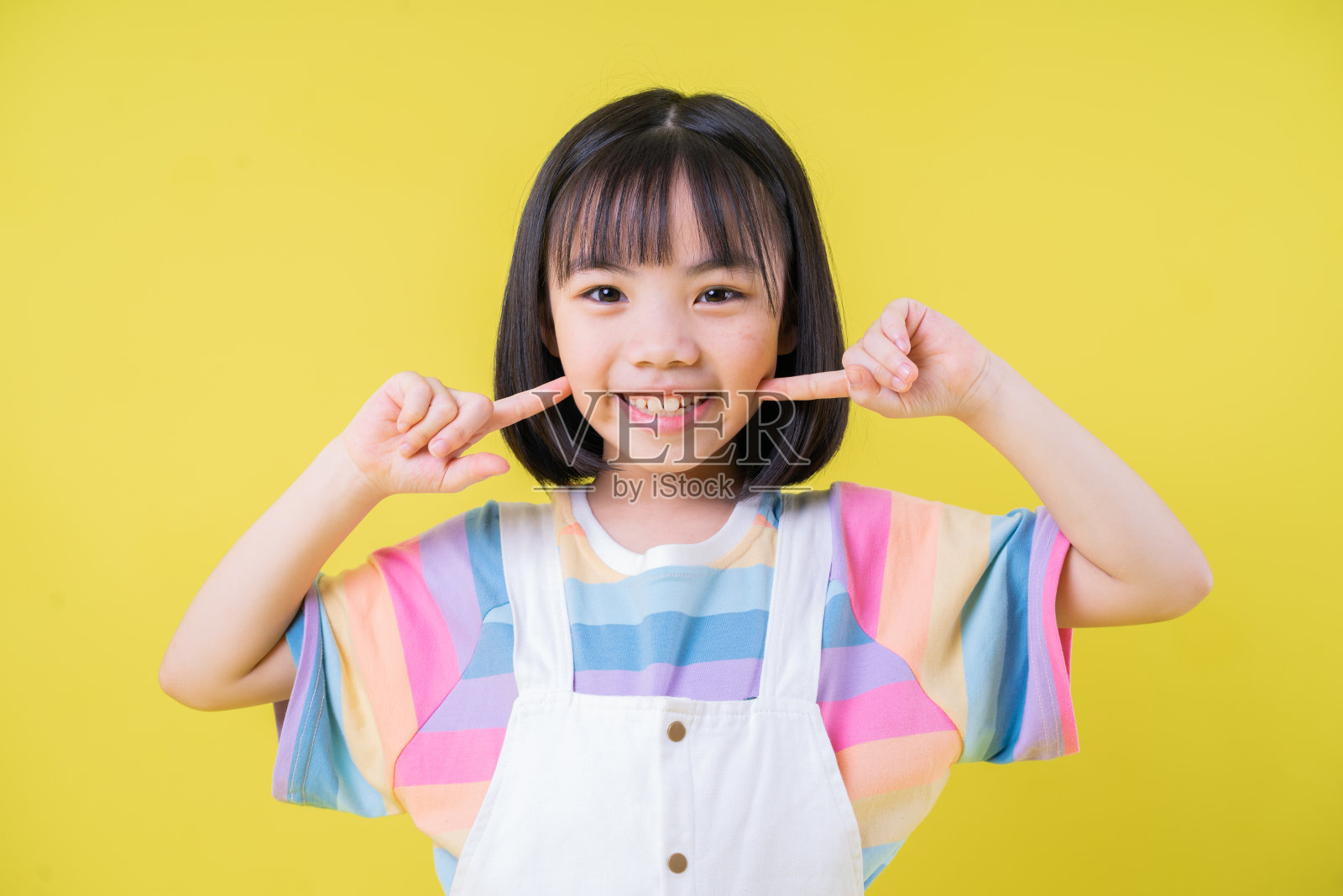 在黄色背景上的亚洲孩子的肖像照片摄影图片