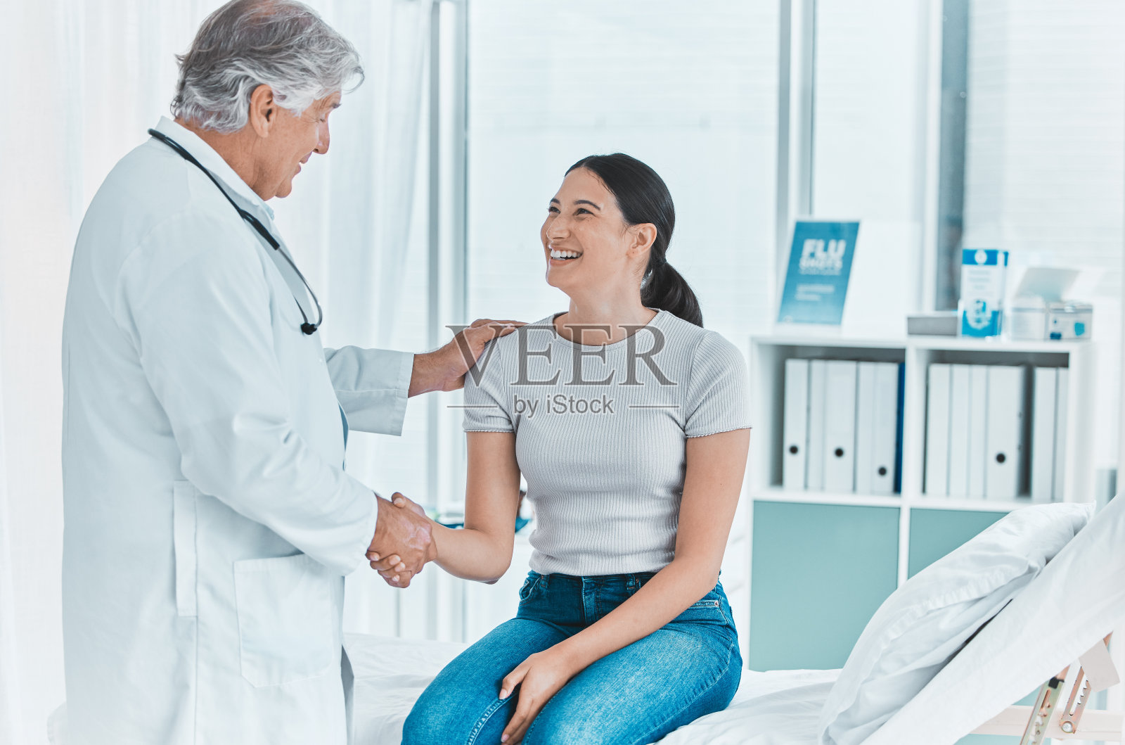 图为一位资深医生与一位病人握手致意照片摄影图片