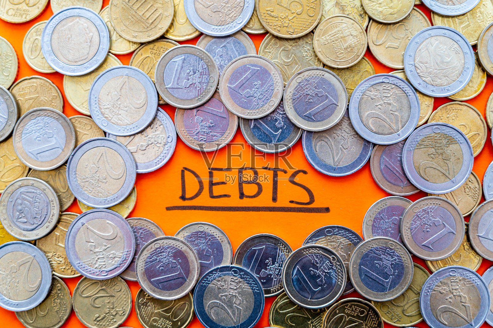 “债务”文字和硬币。不断上升的债务和通货膨胀。照片摄影图片