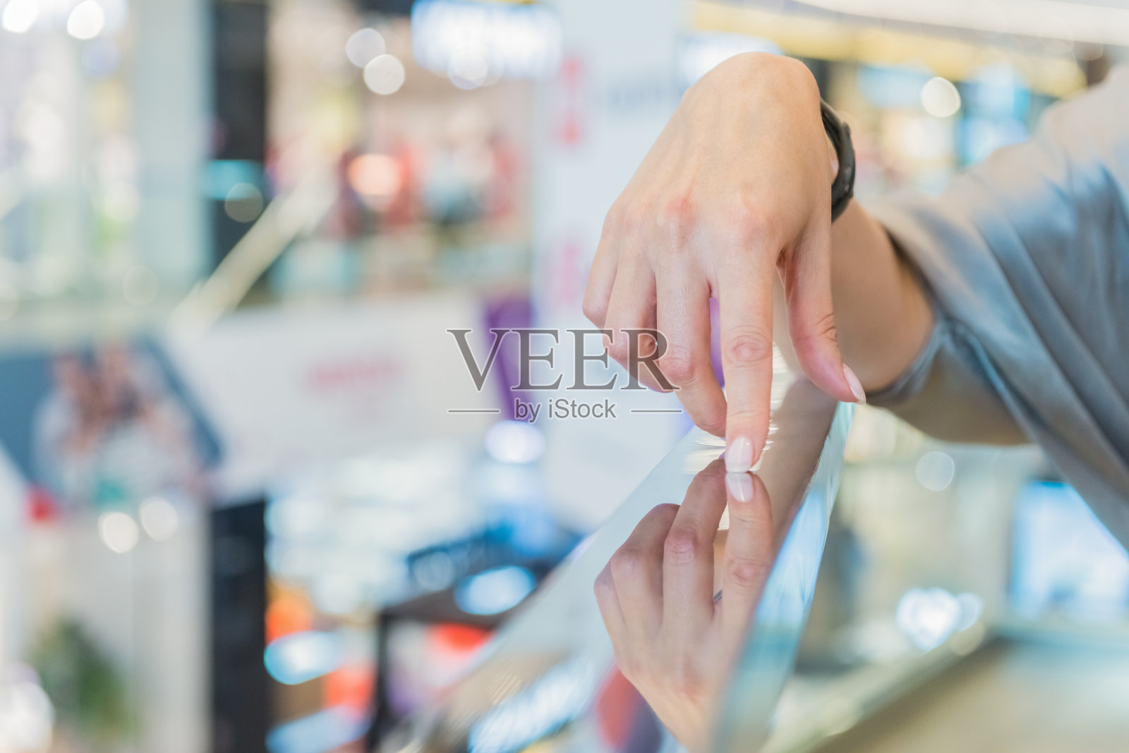 一个女人碰了一根金属栏杆。手手指走路照片摄影图片