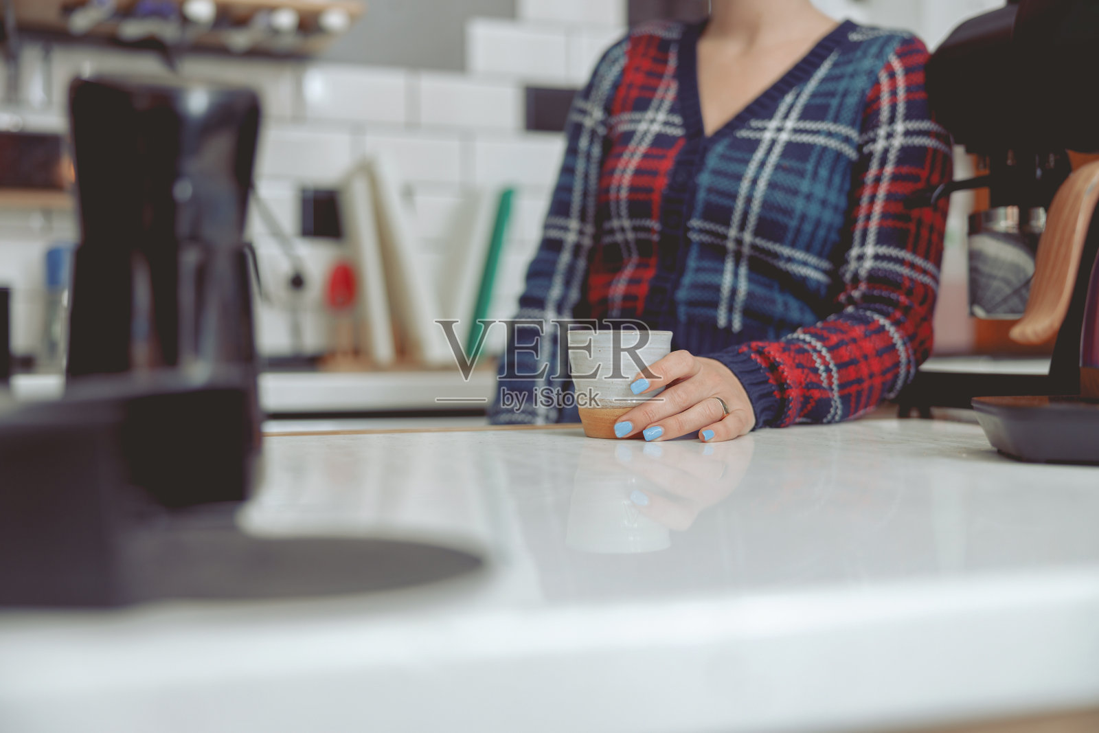 拿着杯子站在吧台后面的女咖啡师照片摄影图片